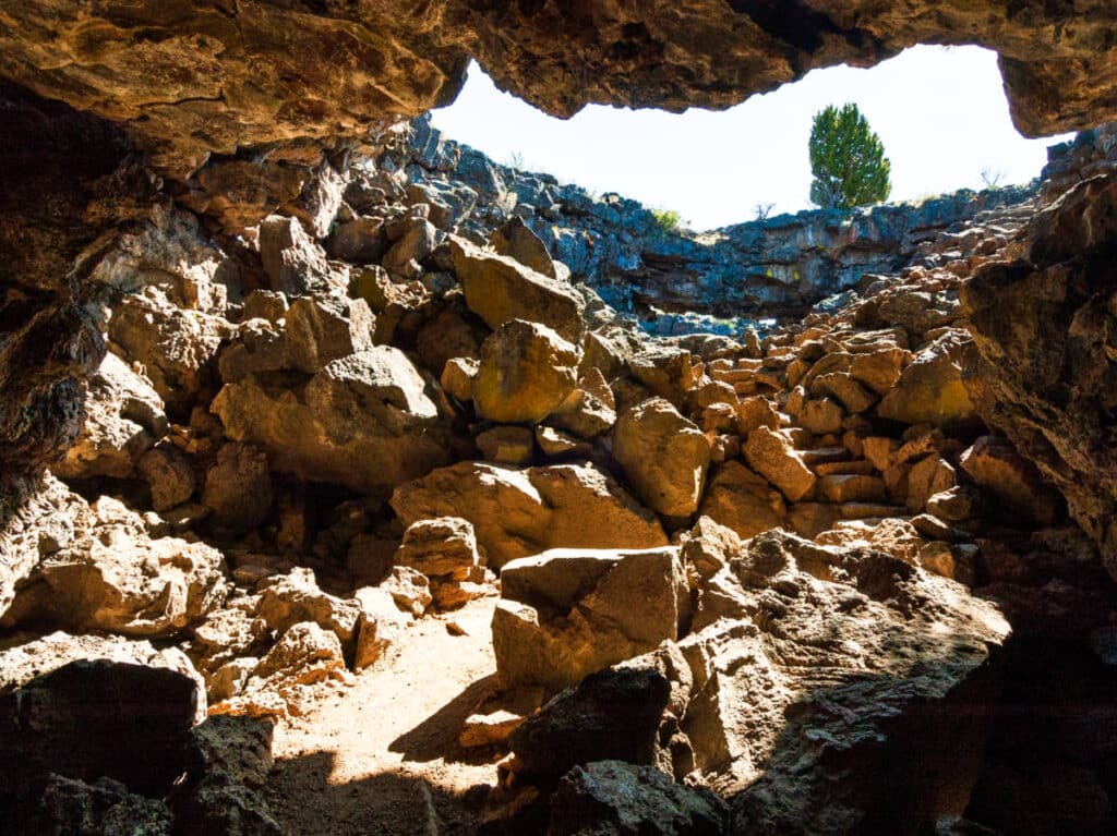 View of the opening of the cave from below the ground in Lava Beds National Monument