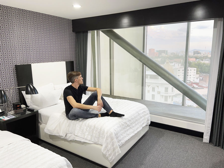 Nate sitting on a bed in Le Meridien