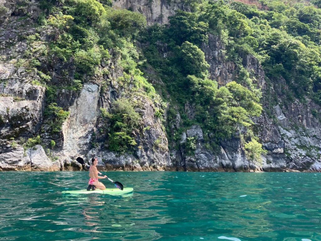 The author, Lea Rose Allbaugh smiling for a photo while paddleboarding