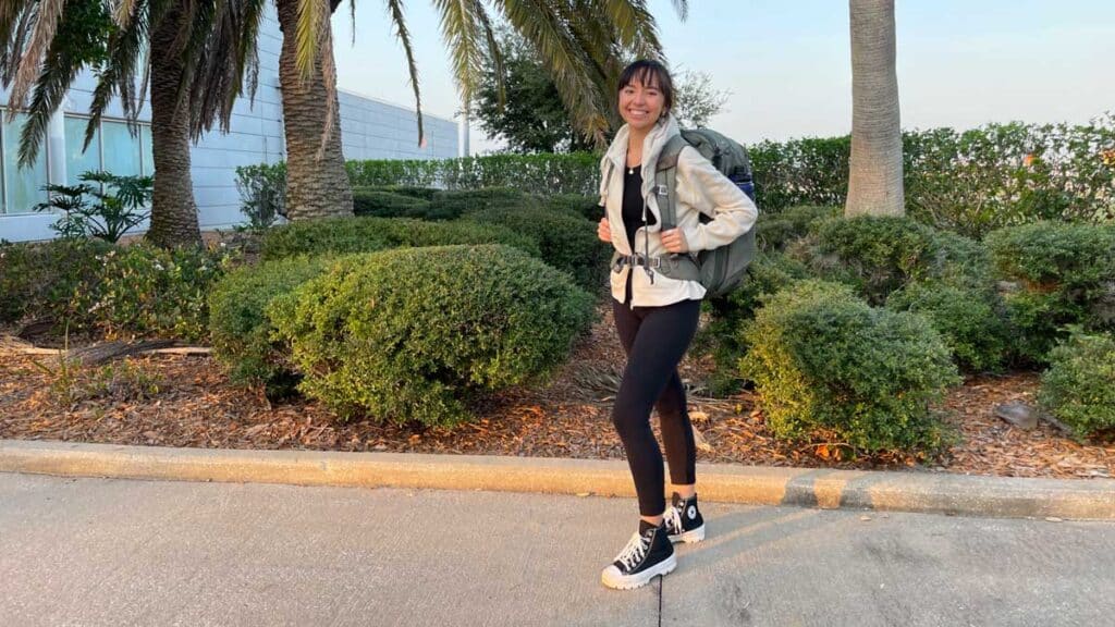 The author of the review Lea Rose Allbaugh smiling for a photo while carrying her Peak Design Travel Backpack