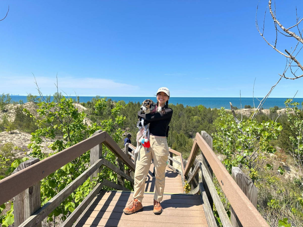 The author Lea Rose Allbaugh carrying her dog at the scenic Indiana Dunes National Park