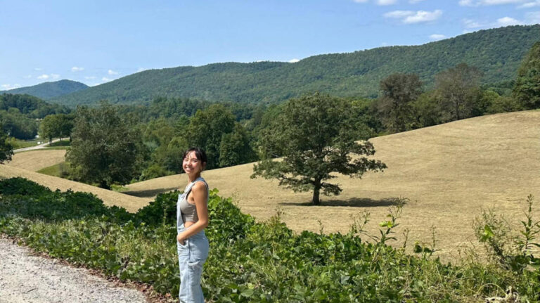 The author Lea Rose Allbaugh posing for a photo with the Blue Ridge Mountains on her background