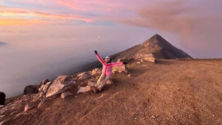 The author, Lea Rose Allbaugh smiling for a photo at the summit of her Acatenango hike