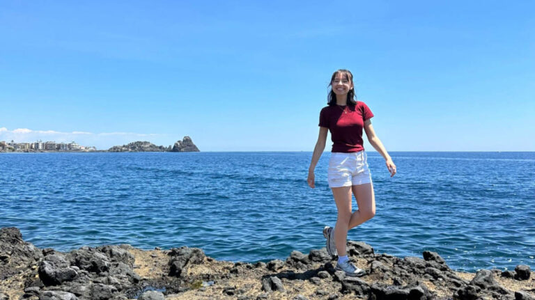 The author Lea Rose Allbaugh smiling for a photo at Aci Castello