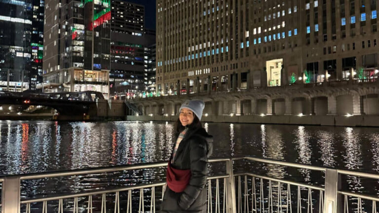 The author, Lea Rose Allbaugh smiling for a photo in Chicago Riverwalk at night
