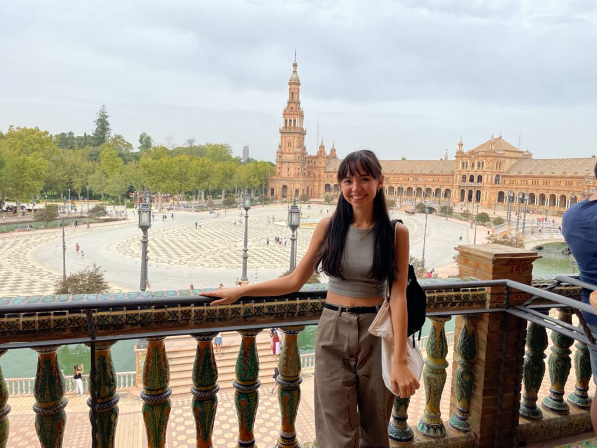 Travel Lemming Editor, Lea Rose Allbaugh, posing for a photo with an overlooking view of the Plaza de España