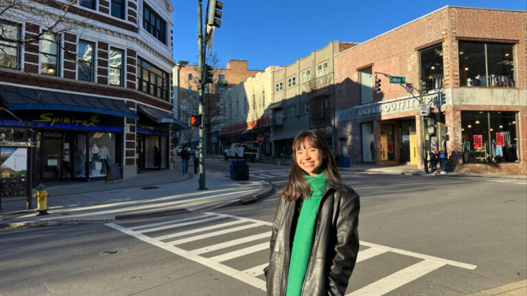 The author Lea Rose, smiling for a photo in downtown Asheville on a sunny day