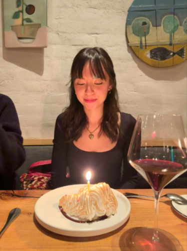 The author Lea Rose wishing on her birthday with a cake on her plate