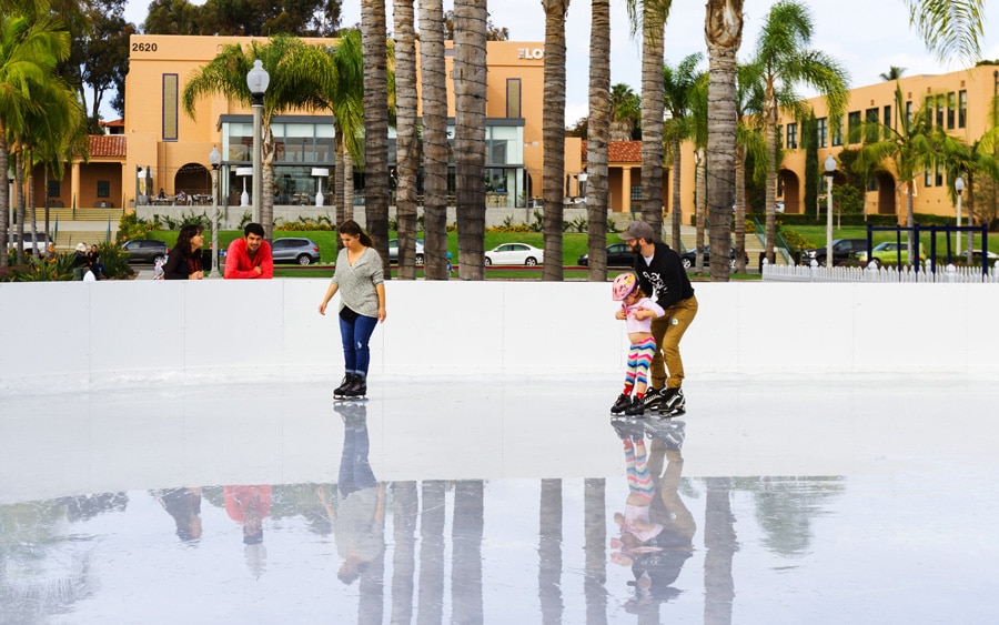 View of a father teaching his daughter how to ice skate
