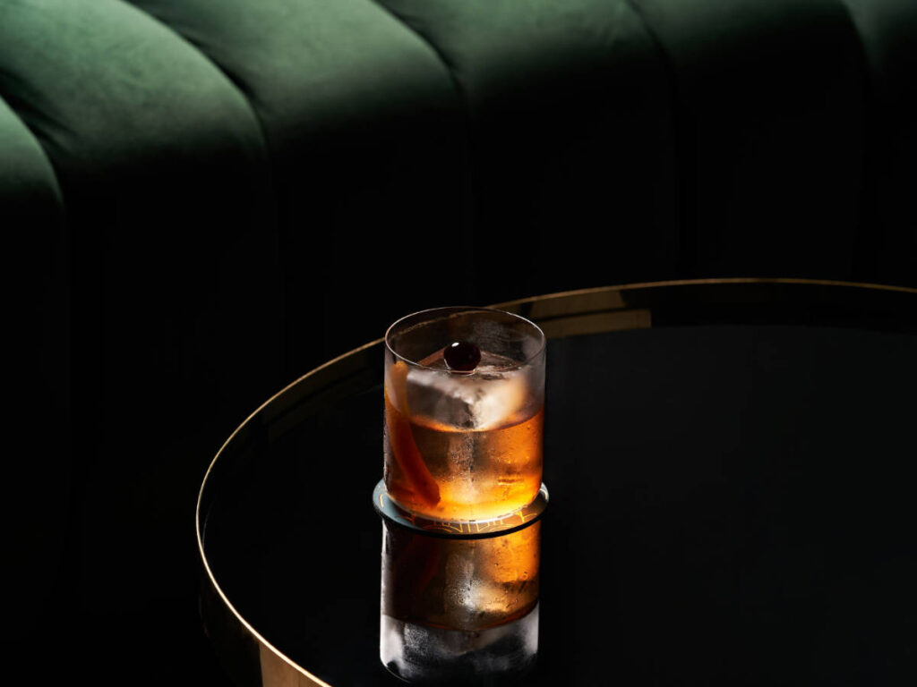 A glass of cocktail on a table in Library Lounge