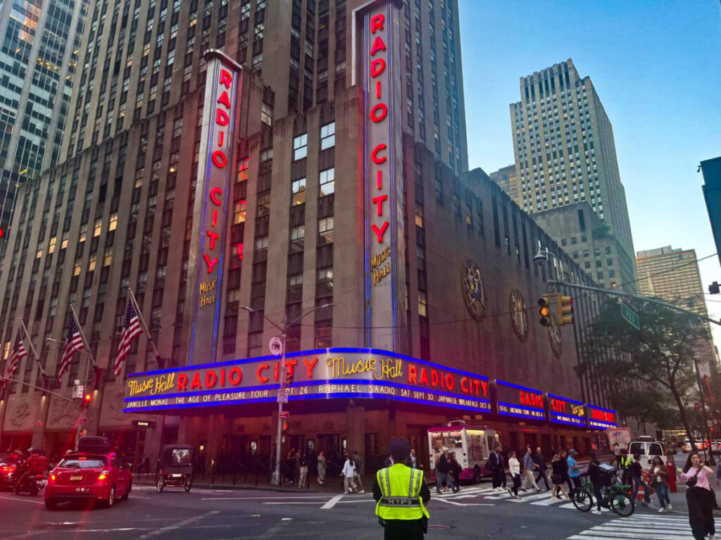 View of the bright lights outside the Radio City Music Hall from across the street