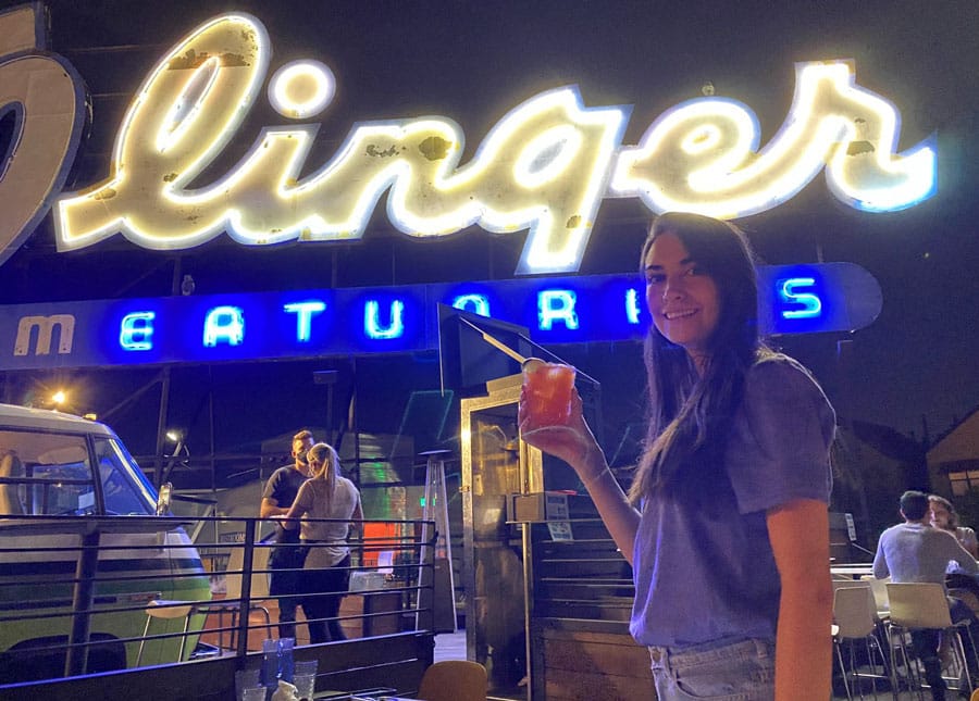 Travel Lemming writer, Clara in front of Linger at night