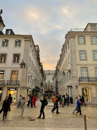 People strolling through wet streets of Lisbon after rain