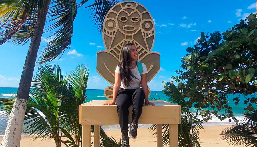 The author posing for a photo while sitting by the beach
