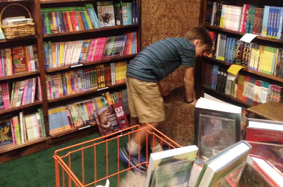 The author's son looking for a book on a shelf
