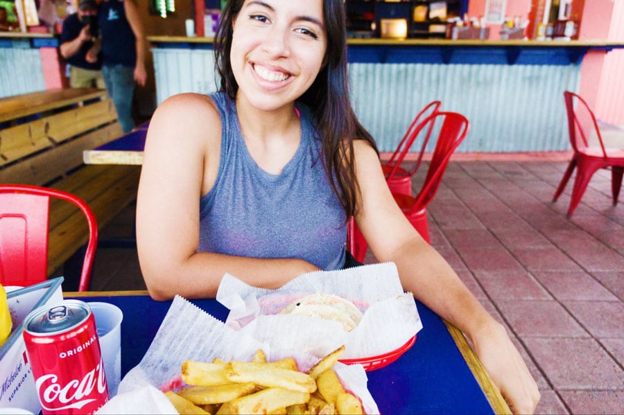 The author smiling for a picture with foods and drinks in front of her