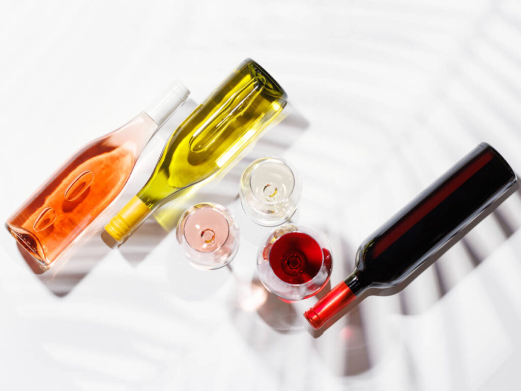 Three wine glasses filled with red, white, and rose wine