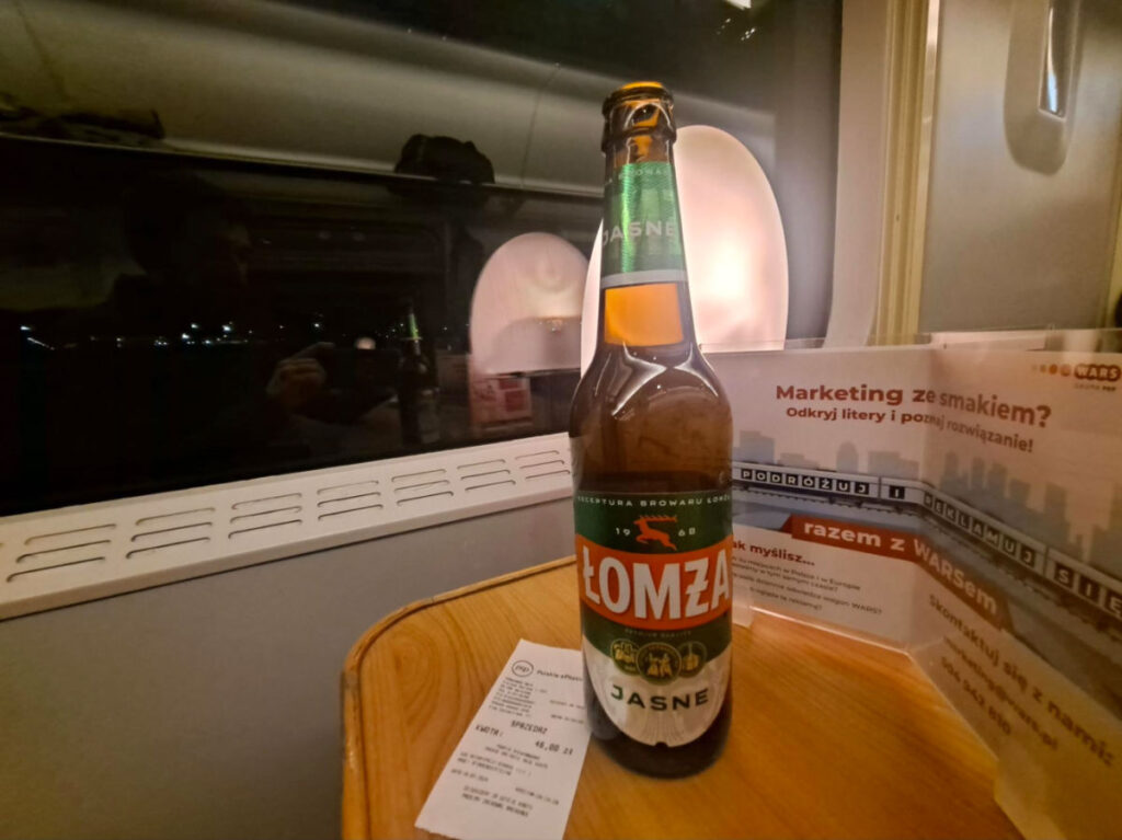 Lomza beer on a table by the window