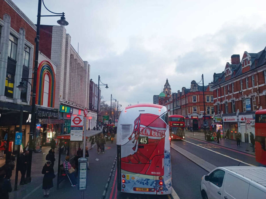 The London bus driving along the bustling street