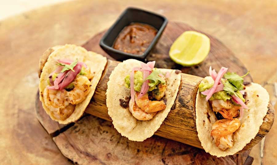 Mexican prawn tacos on a wooden board served at Los Mariscos