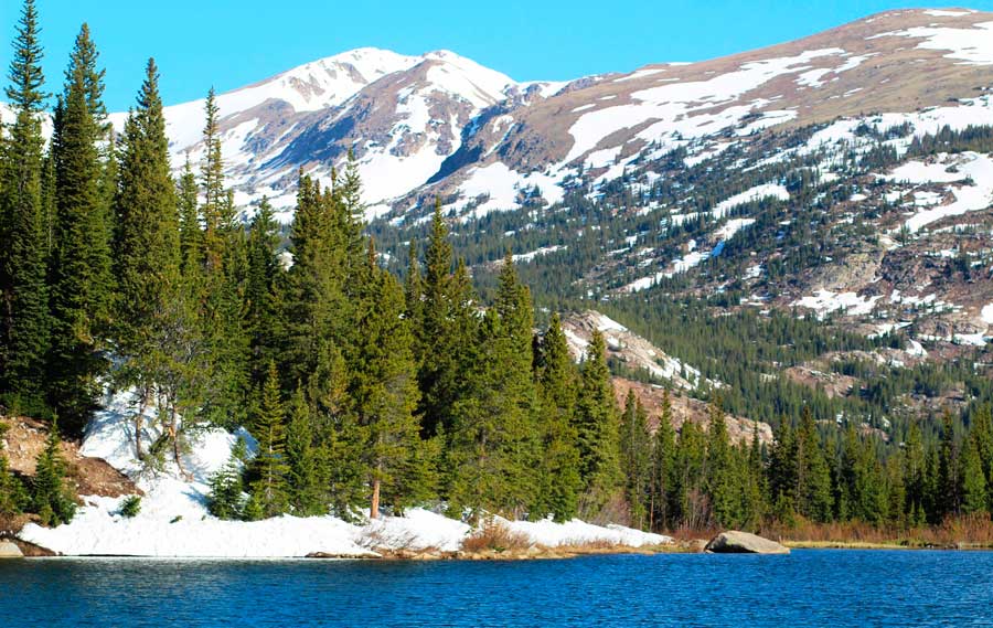 View of the blue water in Lost Lake and a snowy mountain from afar