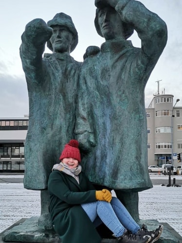 Louise Wylie smiling for a photo with statues in Reykjavik, Iceland