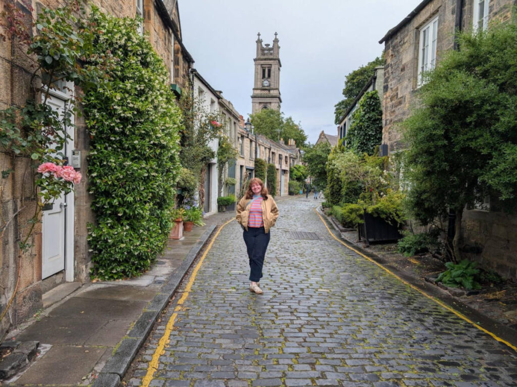 The author Louise Wylie, posing for a photo at the Circus Lane with greenery around