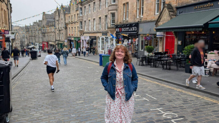 The author Louise Wylie, standing in the middle of the street in the Old Town in Edinburgh