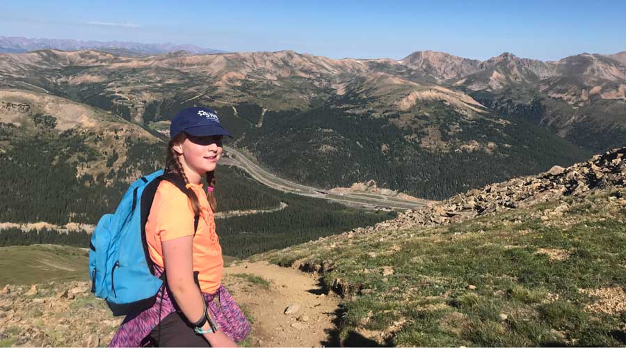 The author's daughter with the overlooking view from Loveland Pass