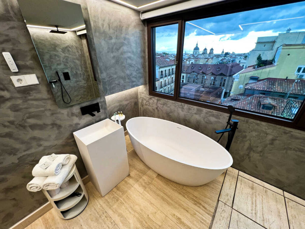 The bathtub in one of the rooms in Madrid 1915 Private Suites with an overlooking view from the window