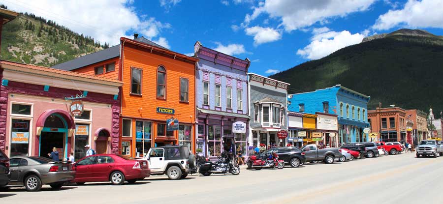 Cars parked in front of colorful stores lined along the main street