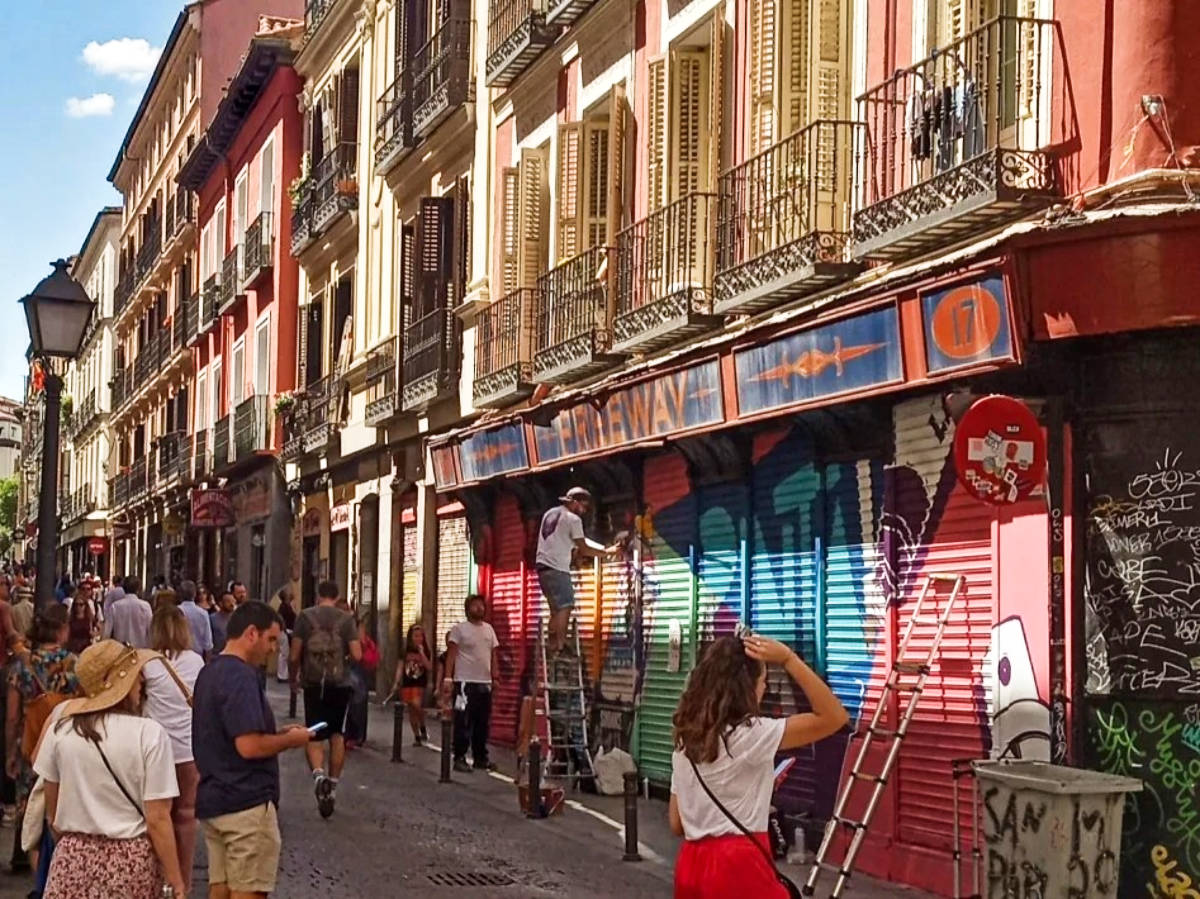 View of the crowd walking along the colorful street of Malasaña