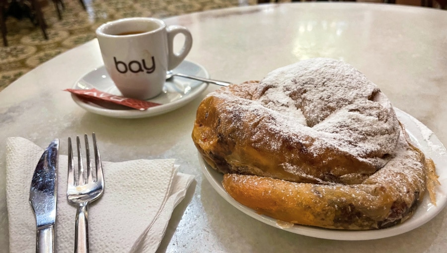 A chocolate filled ensaïmada and a cup of coffee