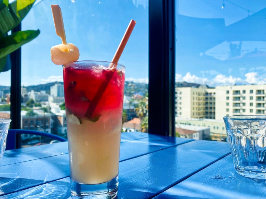 A glass of red and white drink with a scenic view from Mama Shelter