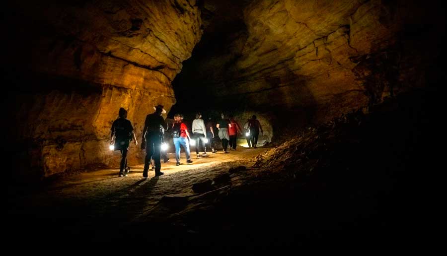 People holding their flashlights inside the Mammoth Cave National Park