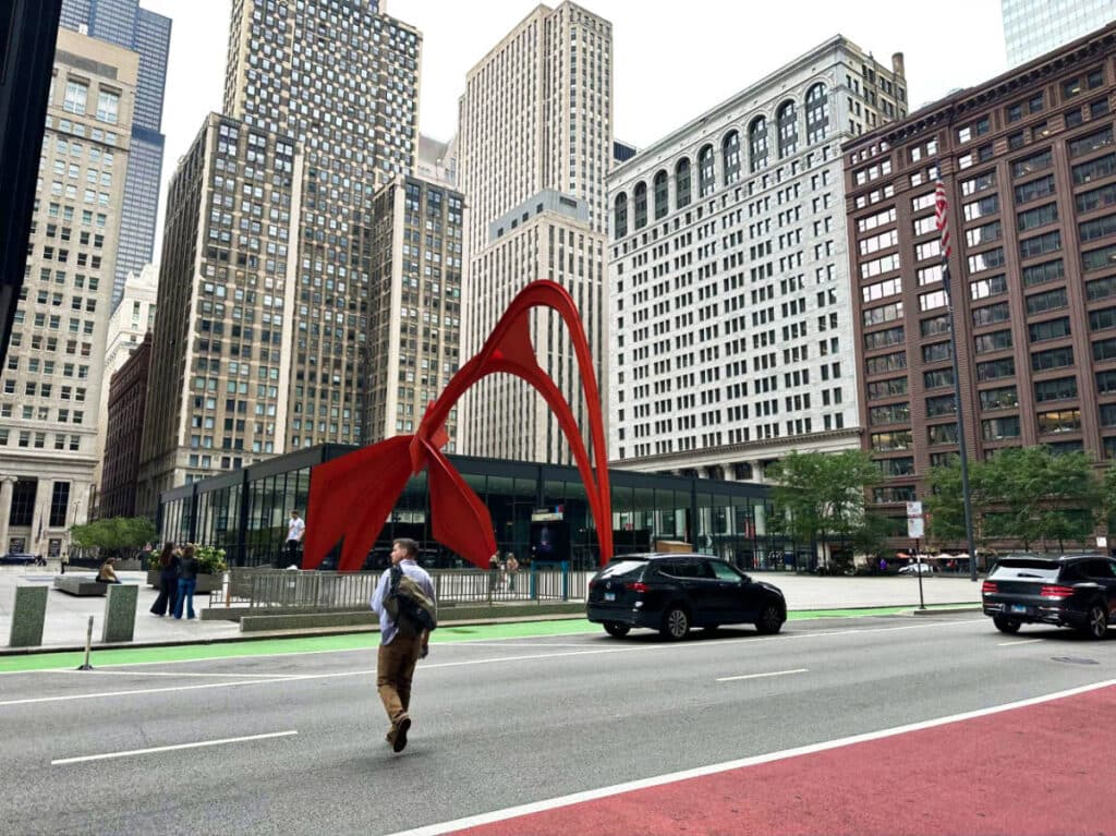 A man crossing the street with the view of the city skyline