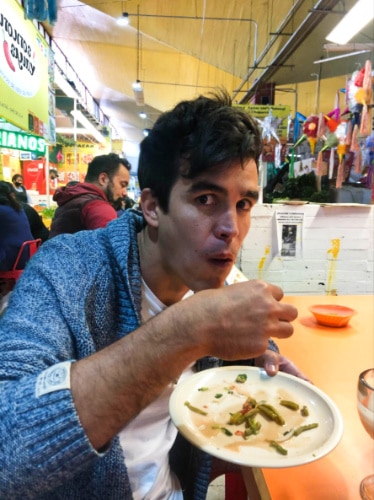 A man emptying the plate with nopales tacos in Coyoacan, Mexico market
