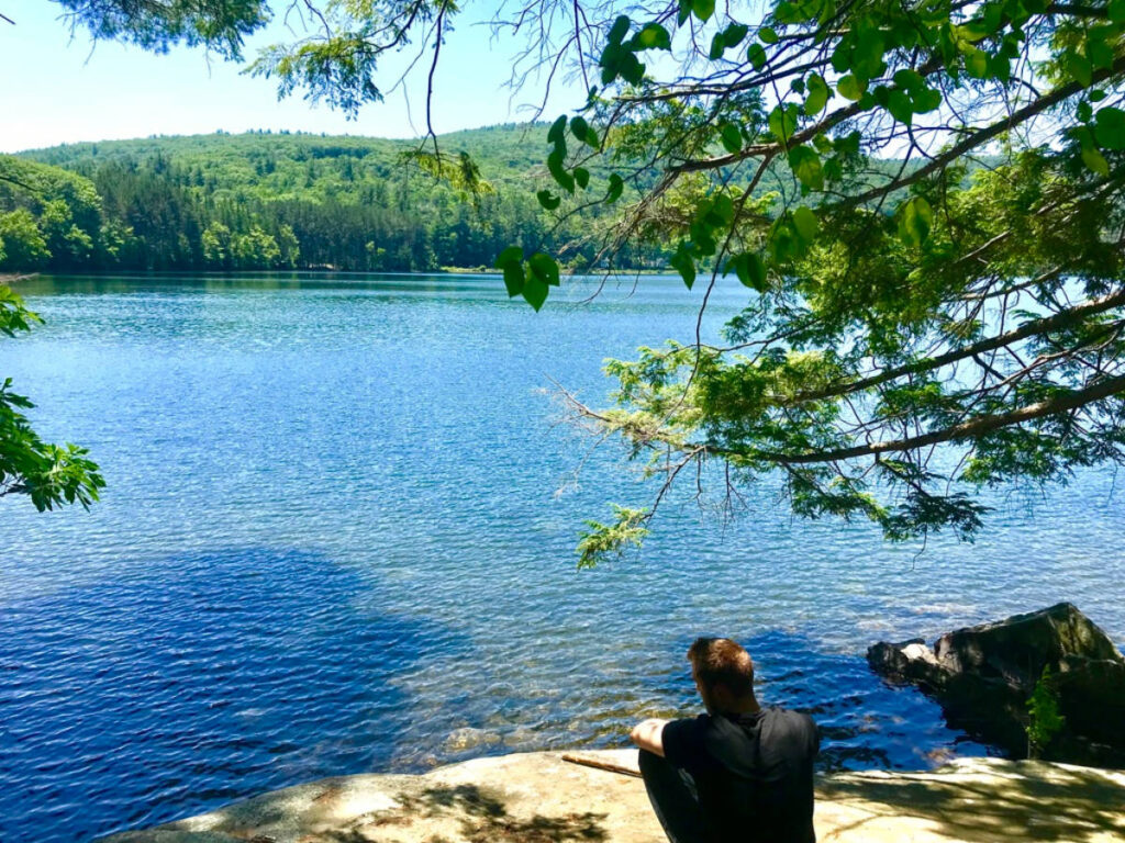 A man relaxing under the shade near the Cooper Lake