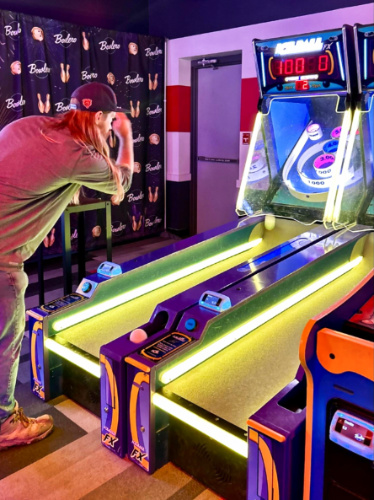 Man playing at an arcade machine in Bowlero