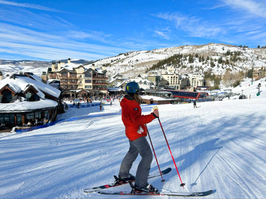 The author Abigail Bliss's husband, posing with the ski-in, ski-out lodging in the background