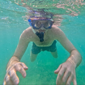 A man snorkeling on a turquoise blue water