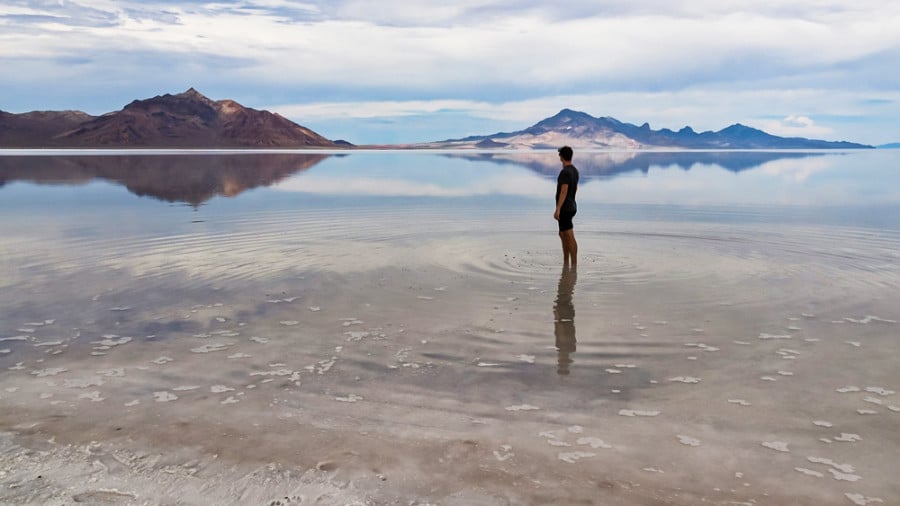 A man standing in the middle of Bonneville Salt Flats lake