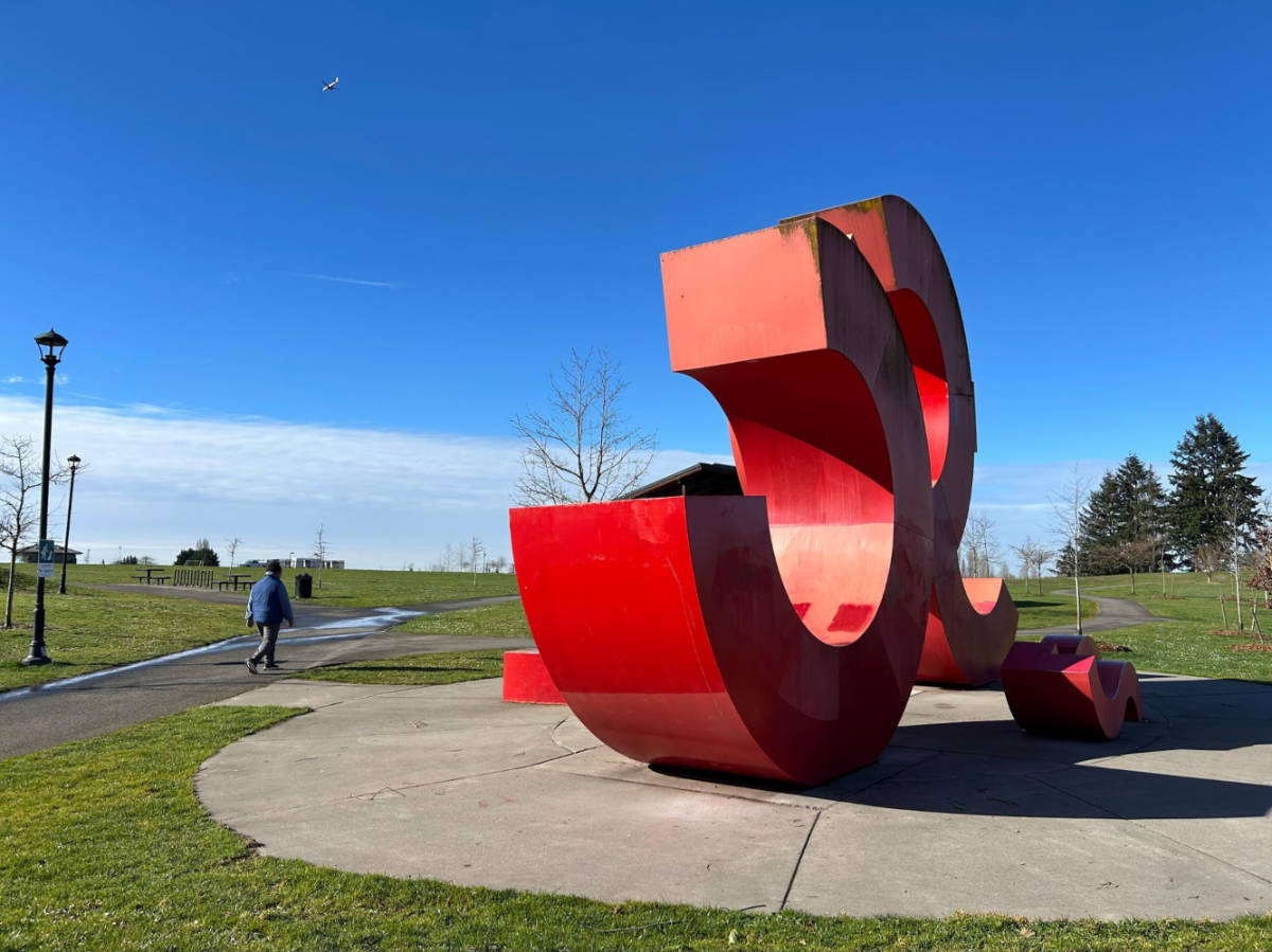 A man walking by a sculpture in Jefferson Park