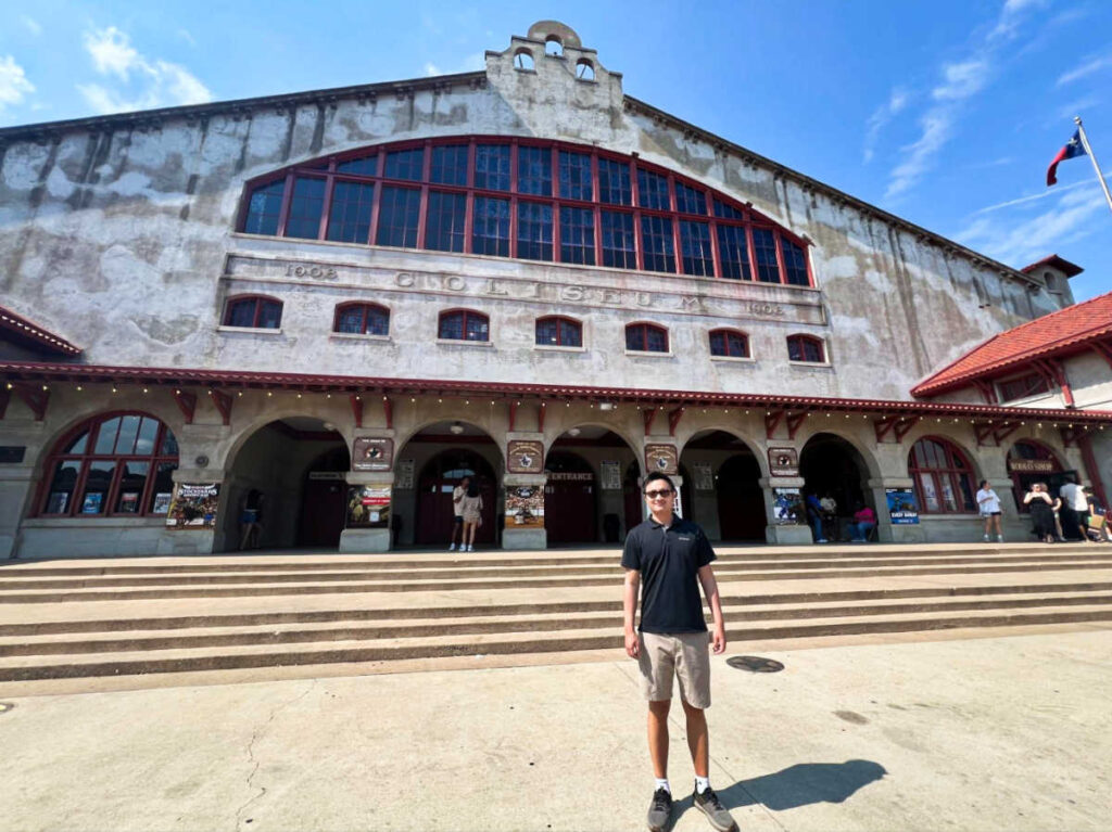 A man in front of the Cowtown Coliseum