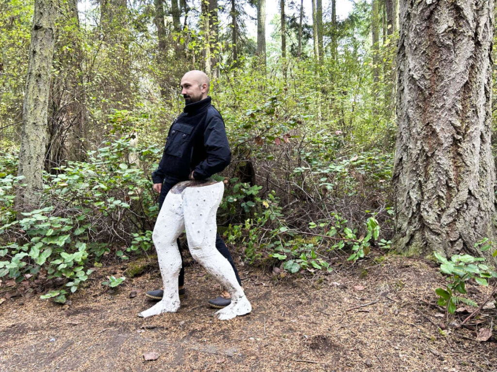 The author Chelsea Booker's husband behind a half body sculpture at Price Sculpture Forest