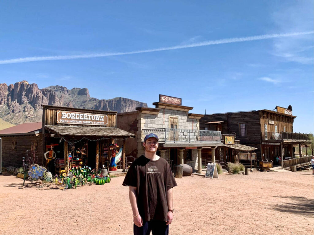 A man standing in front of the shops at the Goldfield Ghost Town