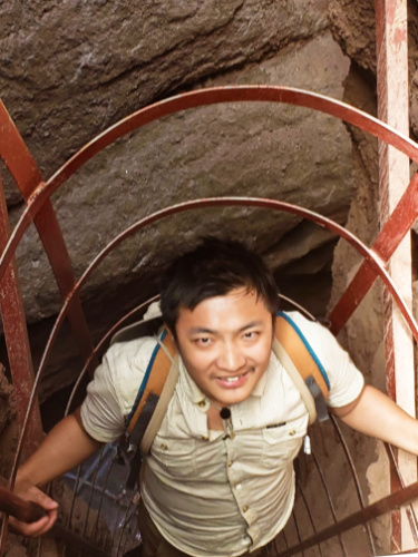 A man climbing on the narrow ladder