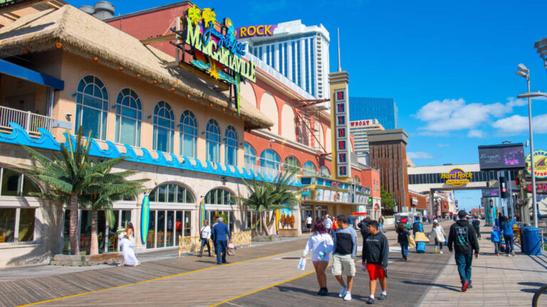 A group of people strolls along the boardwalk in front of Margaritaville