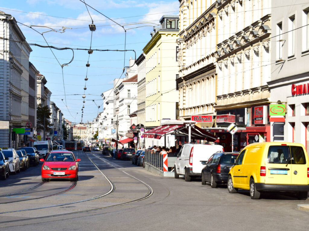 View of cars and shops at Märzstrasse, a street in the 15th district