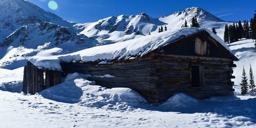 A snow covered cabin with a scenic background in Mayflower Gulch during winter